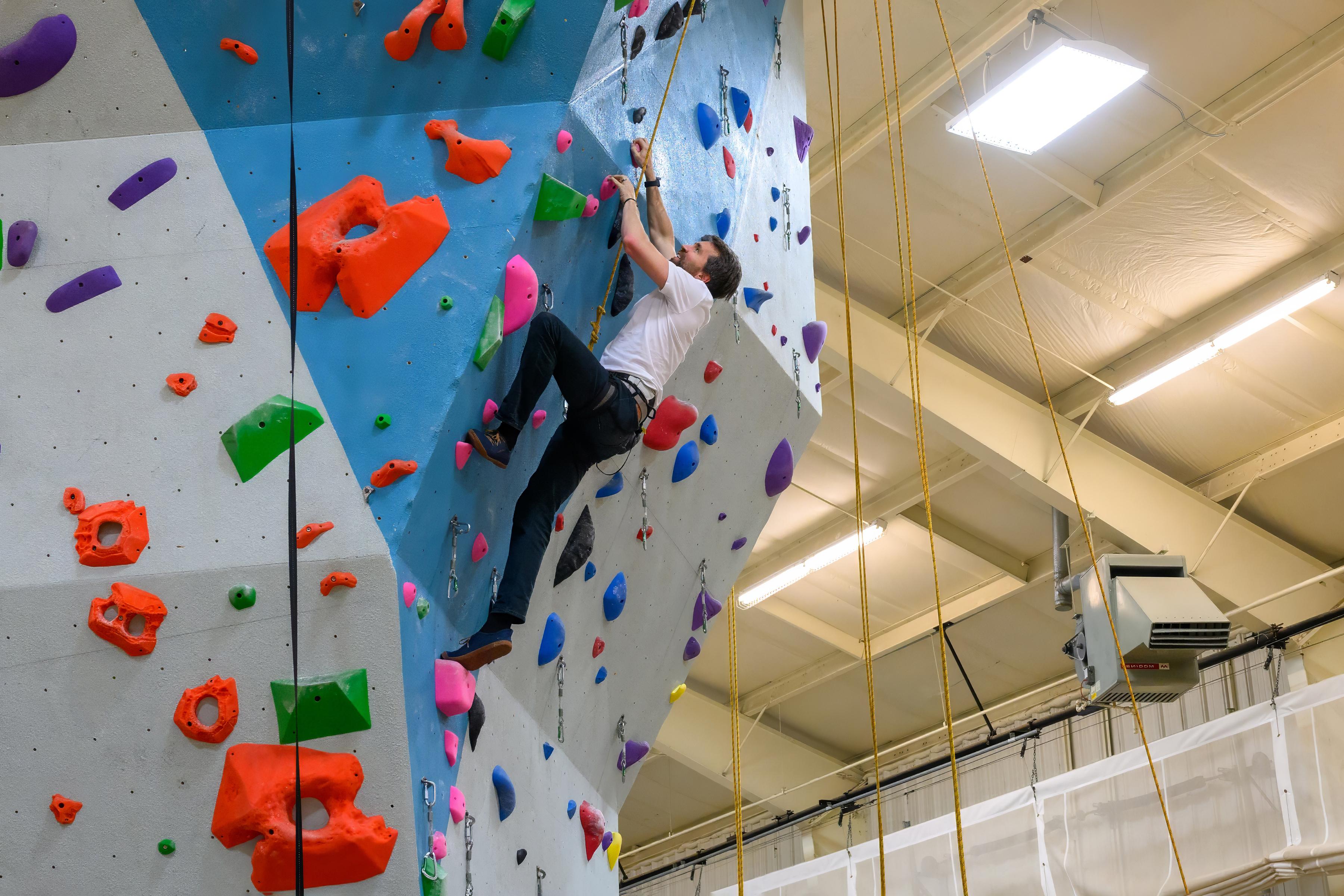 A faculty member using the Outing Club's indoor climbing wall