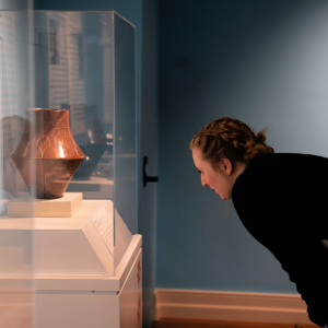 Student looking at piece from Mother Clay exhibit